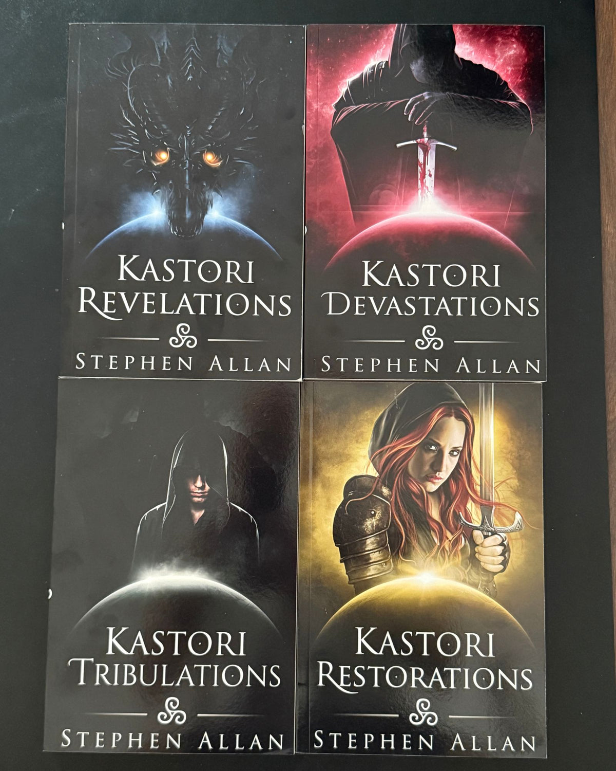 The four Kastori Chronicles paperbacks laid out: Kastori Revelations, Kastori Devastations, Kastori Tribulations and Kastori Restorations